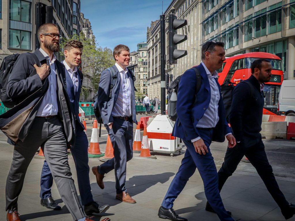 Business people in suits crossing a busy London street